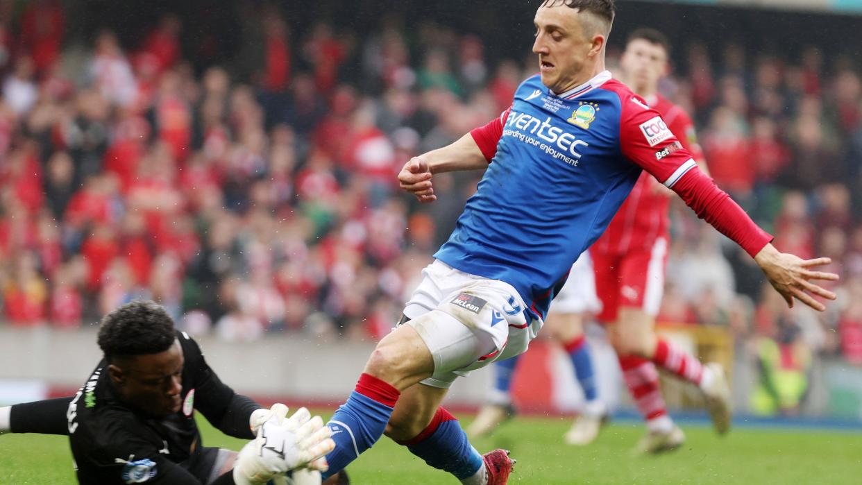 Cliftonville keeper David Odumosu and Linfield's Joel Cooper in the Irish Cup final in May