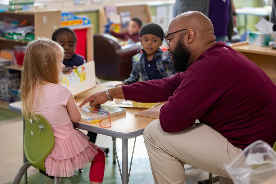 Carlton Collins works with kindergarten students at Rising Stars Academy in Mount Auburn in 2022.