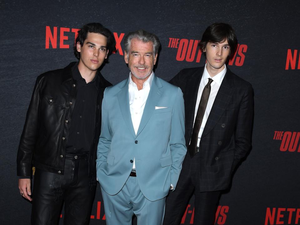 Paris Brosnan, Pierce Brosnan, and Dylan Brosnan pose for photos during a 2023 red carpet.
