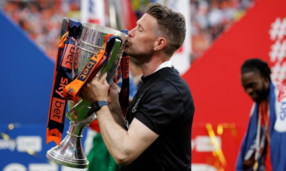 The Luton manager, Rob Edwards, kisses the Championship playoff trophy