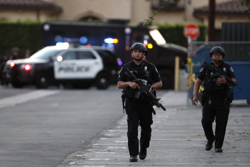 Arcadia, CA, Wednesday, August 10, 2022 - Arcadia Police officers walk a parking lot near a home where an active shooter remains barricaded in a home on Greenfield Ave., after shooting a police officer and others. (Robert Gauthier/Los Angeles Times)