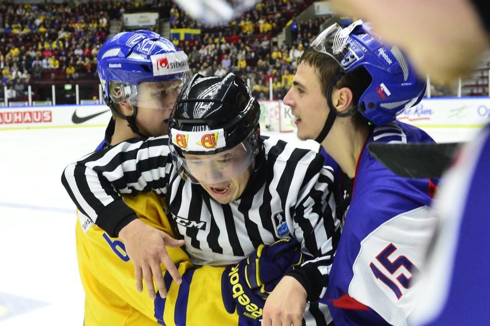 U.S. referee Tim Meyer intervenes during a skirmish between Sweden's Jesper Pettersson, left, and Slovakia's Mario Lunter, right, during the World Junior Hockey Championships quarter final between Sweden and Slovakia at the Malmo Arena in Malmo, Sweden, on Thursday, Jan. 2, 2014. (AP Photo / TT News Agency, Ludvig Thunman) SWEDEN OUT