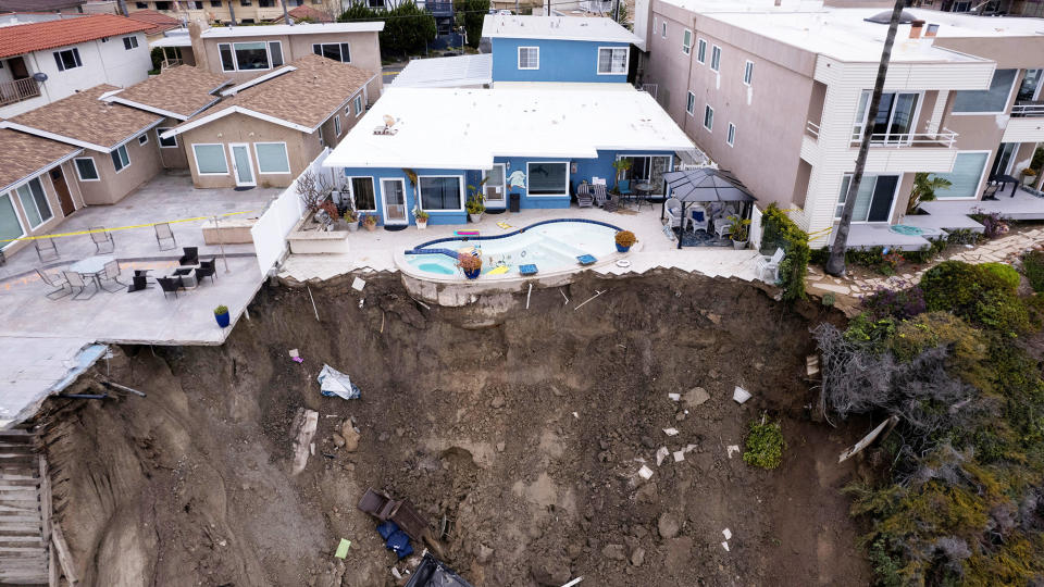 A backyard pool is left hanging on a cliffside after torrential rain wrought havoc on the beachfront town of San Clemente, California, on March 16, 2023. 