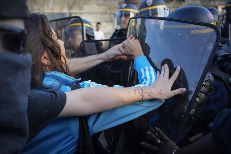 Police officers face protesters on Concorde square during a protest in Paris, France, Friday, June 30, 2023. French President Emmanuel Macron urged parents Friday to keep teenagers at home and proposed restrictions on social media to quell rioting spreading across France over the fatal police shooting of a 17-year-old driver. (AP Photo/Lewis Joly)