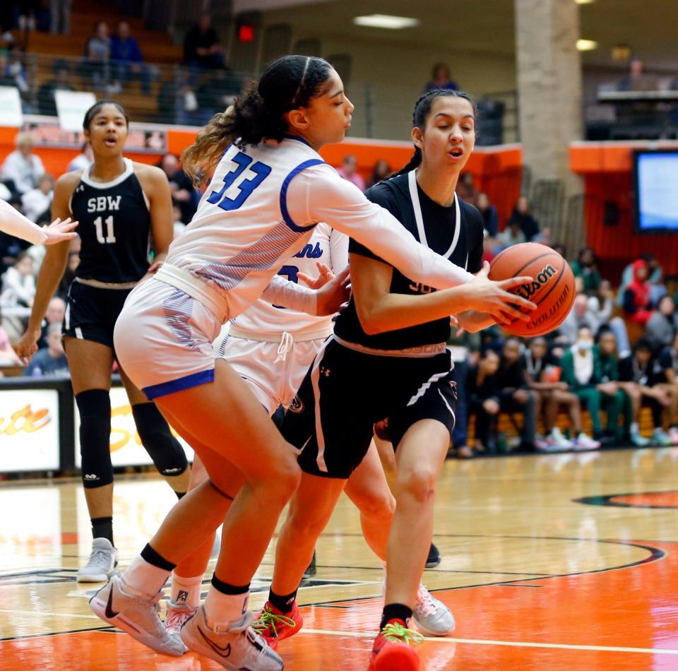 Lake Central senior Aniyah Bishop (33) steals the ball from Washington freshman Kyra Lowe during a Class 4A girls basketball regional championship game Saturday. Feb. 10, 2024 at LaPorte High School.