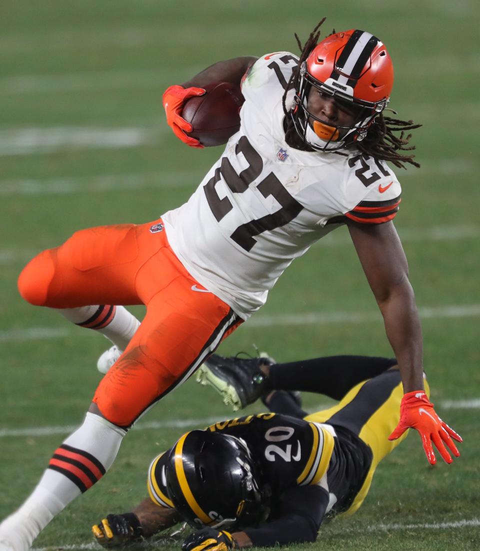 Browns running back Kareem Hunt (27) outruns Pittsburgh Steelers strong safety Cameron Sutton (20) during an NFL wild-card playoff game on Jan. 10, 2021, in Pittsburgh.