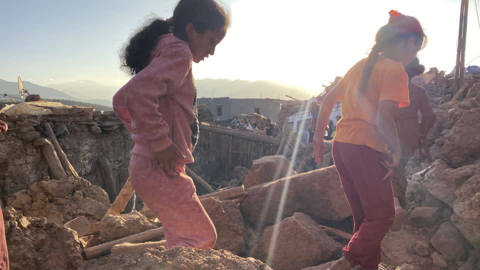 Children make their way through the destroyed village of Tinzert. - Ivana Kottasova/CNN