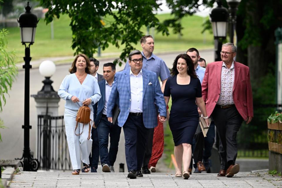 Former MP and Montreal mayor Denis Coderre walks to a news conference with his life partner Annie Pare, friends and supporters, Friday, June 21, 2024  in Quebec City. Coderre announced his decision to run for the Quebec Liberal leadership for the next election. 