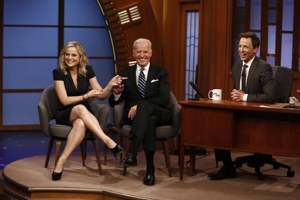 In this photo provided by NBC, from left, actress Amy Poehler and Vice President Joe Biden appear with host Seth Meyers on the premiere of "Late Night with Seth Meyers" on Monday, Feb. 24, 2014, in New York. (AP Photo/NBC, Peter Kramer)