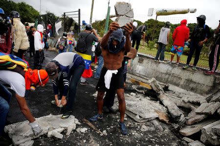 Demonstrators destroy concrete to throw its pieces against riot security forces as they gather in front of an Air Force base during a rally against Venezuelan President Nicolas Maduro's government in Caracas, Venezuela. REUTERS/Ivan Alvarado