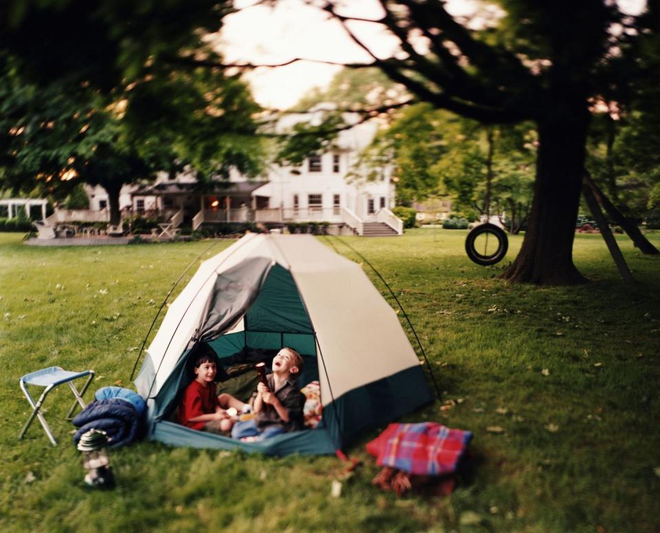 summer activities two kids in a tent in their backyard