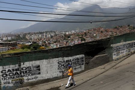 A resident walks past a campaign graffiti of opposition candidate for the government of Miranda Carlos Ocariz ahead the governors elections in Caracas, Venezuela, October 13, 2017. REUTERS/Ricardo Moraes