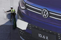 A worker prepares a giant billboard ahead of the Auto Shanghai 2021 show in Shanghai on Sunday, April 18, 2021. Automakers from around the world are showcasing their latest products this week in the world's biggest market for auto vehicles. (AP Photo/Ng Han Guan)