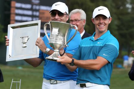 May 17, 2015; Charlotte, NC, USA; Rory McIlroy holds up the championship trophy while his caddy J.P. Fitzgerald who won a caddy trophy during the final round at Quail Hollow Club. Mandatory Credit: Jim Dedmon-USA TODAY Sports