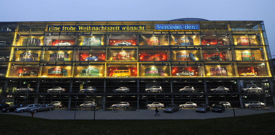 Historic and current German Mercedes cars are wrapped as presents in a giant advent calendar in showrooms at a Mercedes branch in Munich, southern Germany, on Dec. 10, 2008. Every day until Christmas one of the 24 doors reveals a different Mercedes car. Text reads: “A Merry Christmas time from Mercedes.” (AP Photo/Christof Stache)