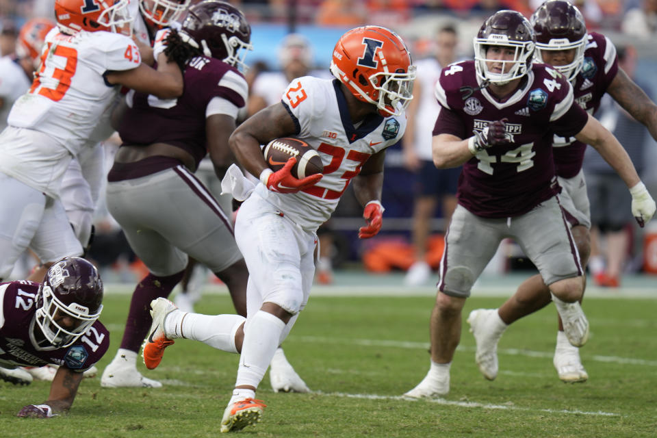 Illinois running back Reggie Love III (23) gets past Mississippi State safety Shawn Preston Jr. (12) and linebacker Jett Johnson (44) during the first half of the ReliaQuest Bowl NCAA college football game Monday, Jan. 2, 2023, in Tampa, Fla. (AP Photo/Chris O'Meara)