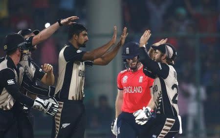 Cricket - England v New Zealand - World Twenty20 cricket tournament semi-final - New Delhi, India - 30/03/2016. New Zealand's Ish Sodhi (C) is congratulated by his teammates after he took the wicket of England's captain Eoin Morgan. REUTERS/Adnan Abidi