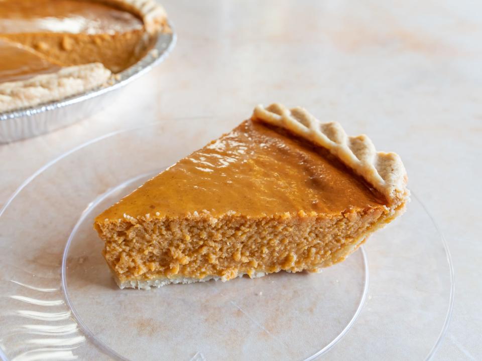 A slice of Safeway's pumpkin pie on a clear plate