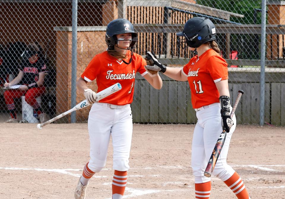 Tecumseh's Lucy Whelan is greeted by Natalie Petty after scoring a run during Monday's doubleheader against Pinckney