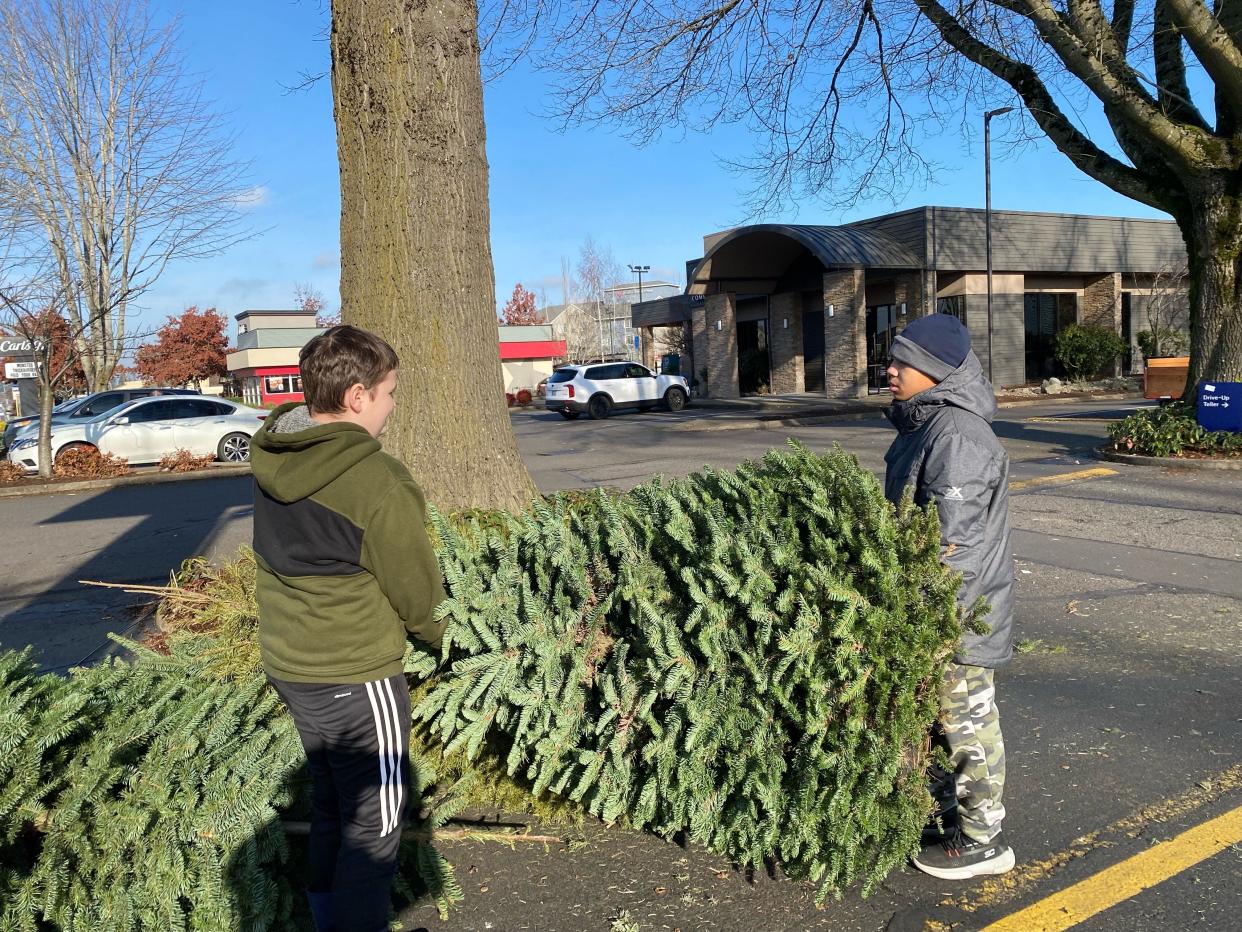 Caden Hamilton, left, and Khainoa Holland haul a tree for a Scouts Troop 121 fundraiser at US Bank in Keizer on Jan. 1, 2022.