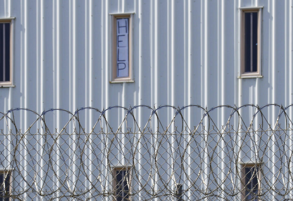 FILE - This Tuesday, Oct. 22, 2019, file photo shows a sign that reads, "HELP," in the window of an inmate cell seen during a tour along with state officials at Holman Correctional Facility in Atmore, Ala. On Monday, April 19, 2021, the underwriter for a project to build two prisons in Alabama announced it is pulling out of the effort. (AP Photo/Kim Chandler, File)