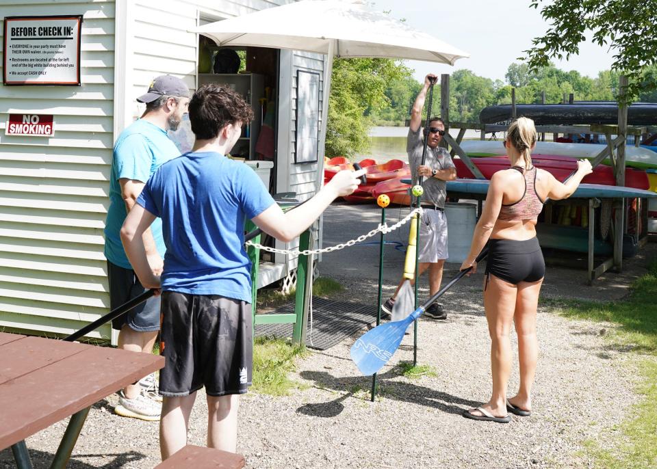 Tecumseh Paddling Co. owner Mark Johnson gives instruction to, from left, Jason Natale, son Colton, 15, and Starr Natale of Hudson on paddling before they head out out onto Globe Mill Pond on June 15, 2022, in Tecumseh.