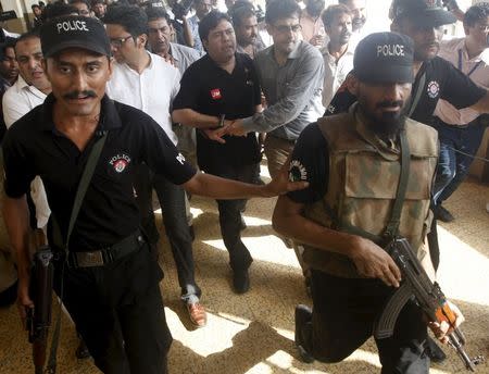 Police and Federal Investigation Agency (FIA) officials escort Shoaib Shaikh (C), CEO of Axact, a Pakistani software company, after he was produced before a district court in Karachi, Pakistan, May 27, 2015. REUTERS/Athar Hussain