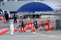 People walk to a taxi queue after leaving the cruise ship Diamond Princess, at the Daikoku Pier Cruise Terminal in Yokohama, south of Tokyo