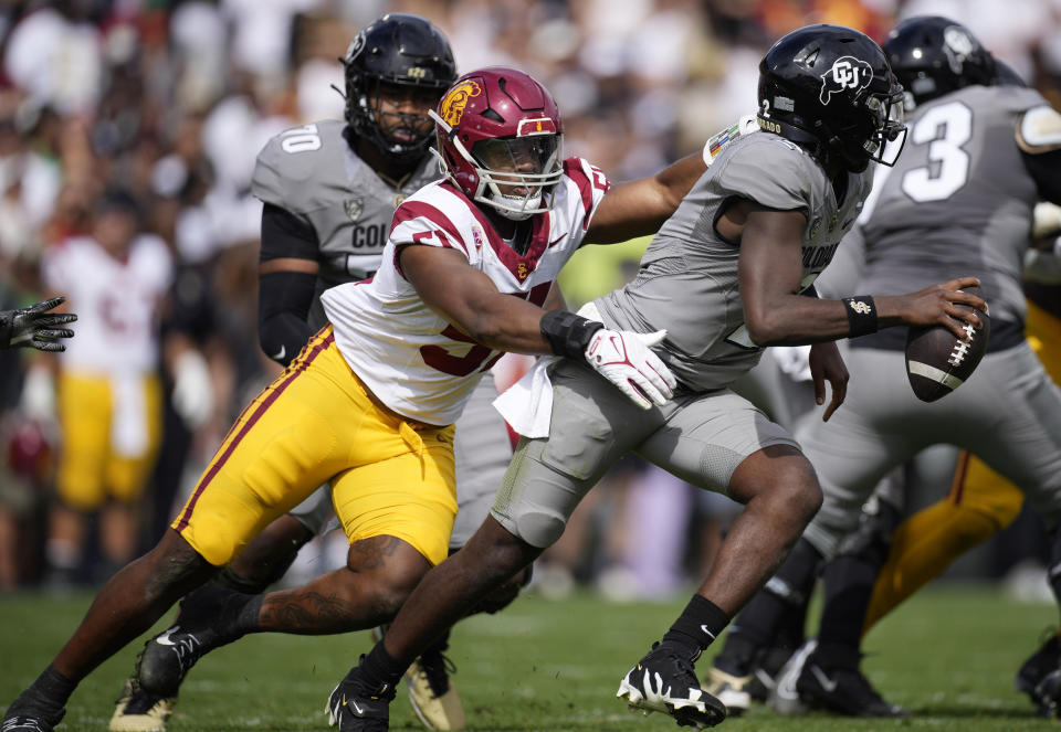 Southern California linebacker Theo Bravos, left, pursues Colorado quarterback Shedeur Sanders in the second half of an NCAA college football game, Saturday, Sept. 30, 2023, in Boulder, Colo. (AP Photo/David Zalubowski)