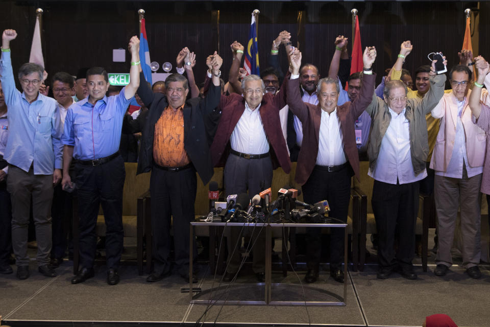 FILE - In this May 9, 2018, file photo, Mahathir Mohamad, center, celebrates during a meeting of coalition leaders, at a hotel in Kuala Lumpur. Malaysia's alliance government under 94-year-old Prime Minister Mahathir is threatening to unravel less than two years after a historic election victory ousting the coalition that had ruled the country since independence.(AP Photo/Vincent Thian, File)