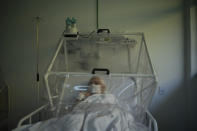 An elderly COVID-19 patient is treated inside a non-invasive ventilation system named the Vanessa Capsule at a municipal field hospital Gilberto Novaes in Manaus, Brazil, Monday, May 18, 2020. The field hospital, set up inside a school, has nearly 150 beds and is operating near its limit as it treats patients both from the capital and remote Amazon areas. (AP Photo/Felipe Dana)