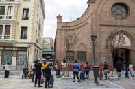 People queue to receive food at San Ramon Nonato Catholic parish in Puente de Vallecas district in Madrid, Spain, Saturday, Sept. 19, 2020. Authorities in Madrid, the European capital experiencing the worst second-wave outbreak, are introducing new curbs on social gatherings starting Monday. (AP Photo/Manu Fernandez)