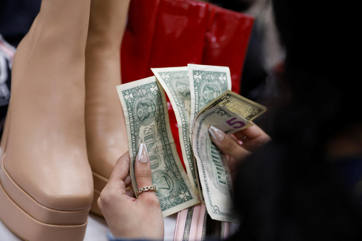 A customer pays for shoes with cash in a store at a shopping center during Black Friday sales, in Caracas, Venezuela November 25, 2022. REUTERS/Leonardo Fernandez Viloria