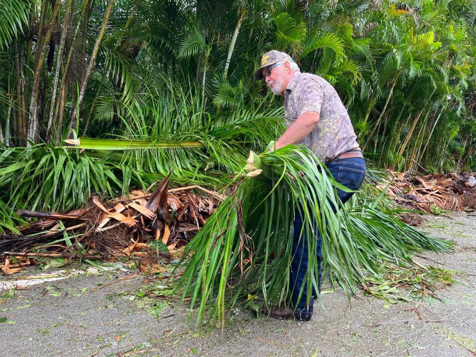 A resident of Indian River Drive in Cocoa pulls debris from the road around 10 a.m. Thursday morning.