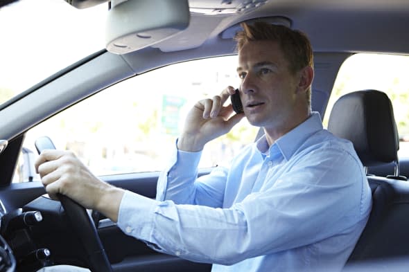 Businessman driving while on phone