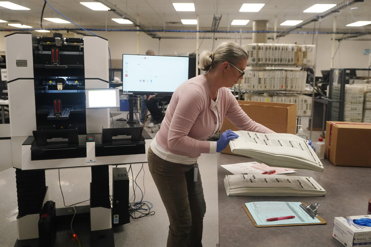 An election worker holds a stack of counted ballots at the Maricopa County Recorders Office in Phoenix, Thursday, Nov. 10, 2022. (AP Photo/Ross D. Franklin)