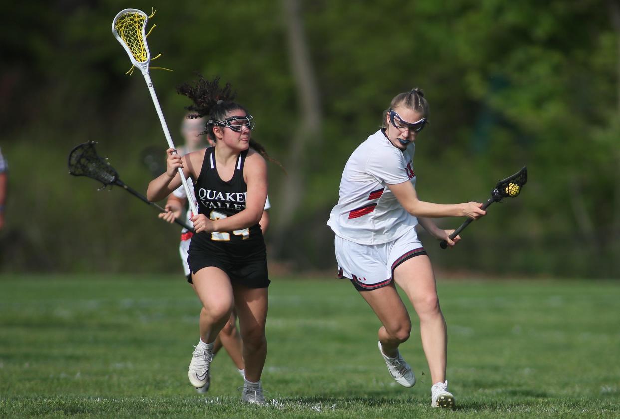 Sewickley Academy's Libby Eannarino (2) races downfield while being guarded by Quaker Valley's Lucy Roig (24) during the second half Monday evening at Nichols Field in Sewickley, PA.