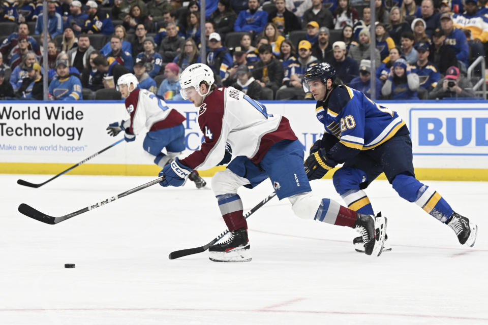 Colorado Avalanche's Bowen Byram (4) advances the puck against St. Louis Blues' Brandon Saad (20) during the second period of an NHL hockey game Wednesday, Dec. 29, 2023, in St. Louis. (AP Photo/Michael Thomas)