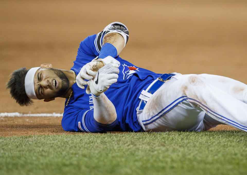 TORONTO, ONTARIO - AUGUST 8: Lourdes Gurriel Jr. #13 of the Toronto Blue Jays reacts after being injured on a play at first base against the New York Yankees in the ninth inning during their MLB game at the Rogers Centre on August 8, 2019 in Toronto, Canada. (Photo by Mark Blinch/Getty Images)