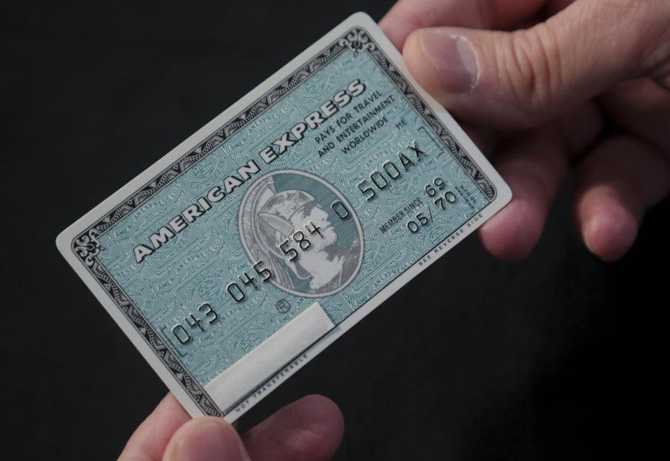 In this Wednesday, Oct. 23, 2019, photo Ira Galtman, American Express director of corporate archives, shows an original American Express "Green Card" from its collection in New York. For 50 years, "Green Card" was everywhere and now it's getting a much-needed revamp, with a new look and more travel benefits. (AP Photo/Bebeto Matthews)