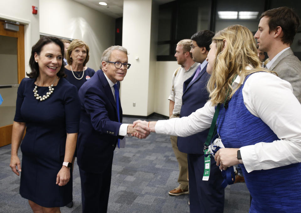 Ohio Attorney General and Republican gubernatorial candidate Mike DeWine, center, is greeted in the spin room following a debate against Ohio Democratic gubernatorial candidate Richard Cordray at the University of Dayton Wednesday, Sept. 19, 2018, in Dayton, Ohio. (AP Photo/Gary Landers)