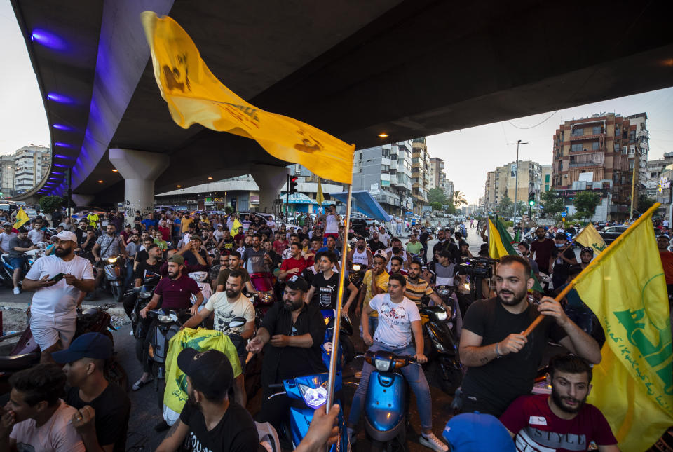 Hezbollah and Amal supporters wave Hezbollah flags as people shout slogans against Israel and U.S. during a protest in the southern suburb of Beirut, Lebanon, Sunday, June 28, 2020. The protest came hours after Lebanon's foreign minister summoned the U.S. ambassador to Beirut over comments, she made recently in which she criticized Hezbollah. The meeting between Foreign Minister Nassif Hitti and Ambassador Dorothy Shea is scheduled for Monday afternoon. (AP Photo/Hassan Ammar)