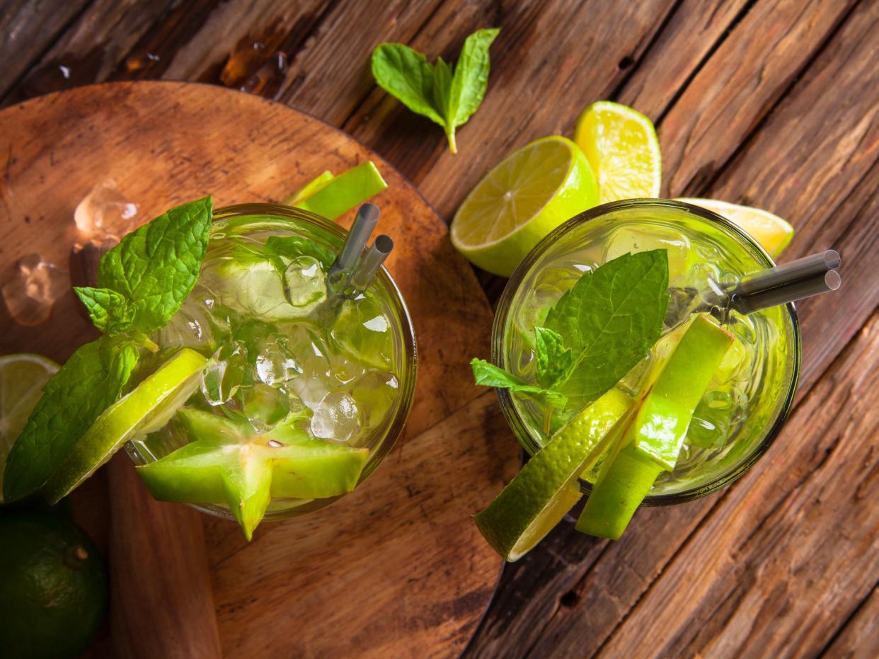 Summer lime cocktail, drink with fresh fruits on wooden table.