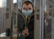 A passenger wears a face mask to protect from coronavirus check in a counter operated by plastic in the departure hall in Ben Gurion Airport near Tel Aviv, Israel, Sunday, Jan. 24, 2021 during a nationwide lockdown to curb the spread of the virus COVID-19. Prime Minister Benjamin Netanyahu on Sunday said Israel was closing its international airport to nearly all flights as the government races to bring a raging coronavirus outbreak under control. (AP Photo/Ariel Schalit)