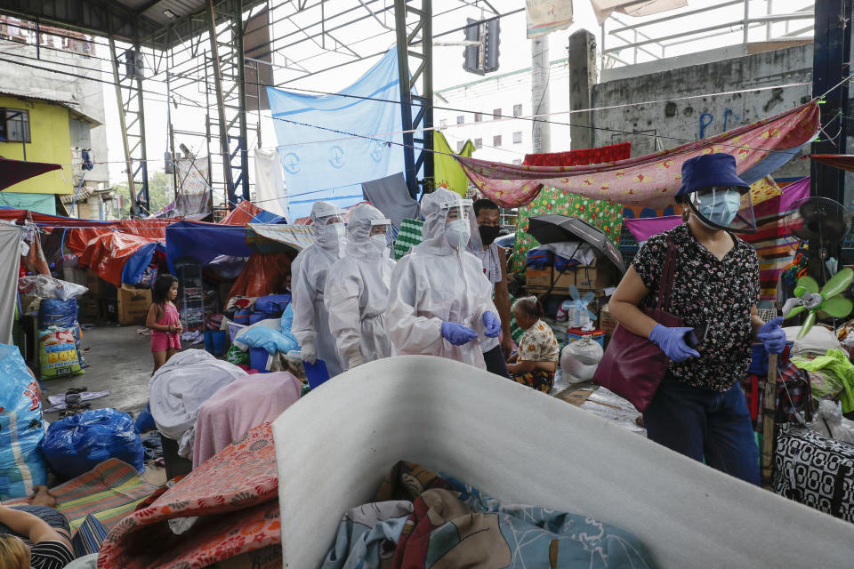 Health workers wearing protective suits visit a slum area to immunize small children against measles during an enhanced community quarantine to prevent the spread of the new coronavirus in Manila, Philippines on Tuesday May 5, 2020. (AP Photo/Aaron Favila)