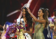 Catriona Gray de Filipinas, izquierda, sonríe al recibir la corona de Miss Universo 2018 de manos de Miss Universo Demi-Leigh Nel-Peters durante la final de la 67ma edición de Miss Universo en Bangkok, Tailandia, el 17 de diciembre de 2018. (Foto AP/Gemunu Amarasinghe)