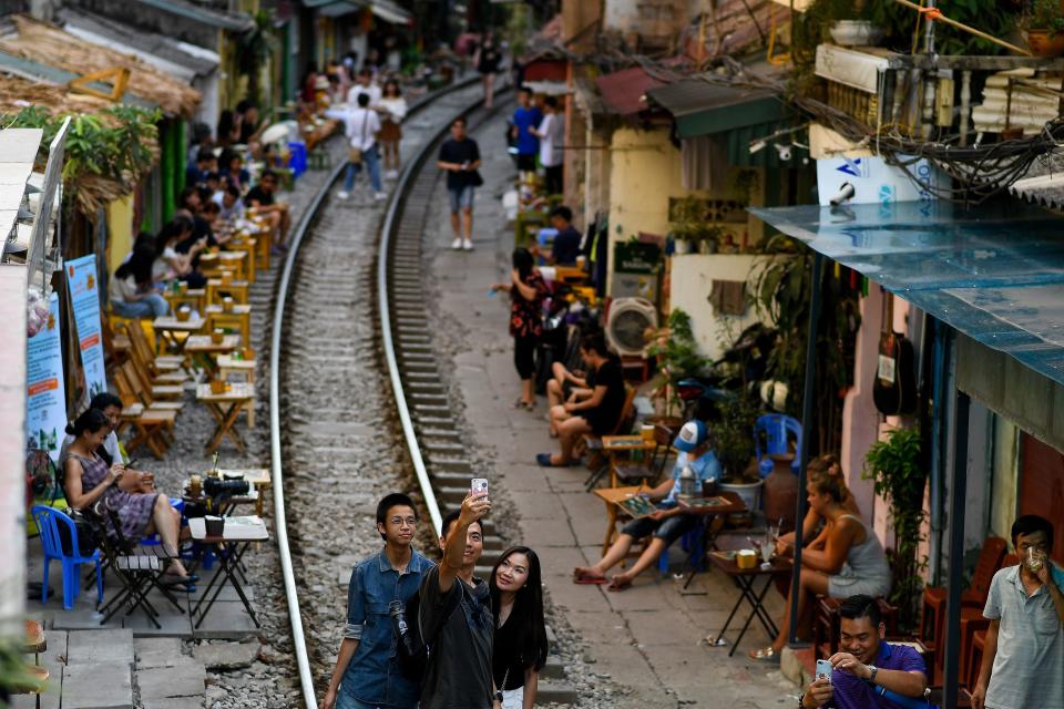 This photograph taken on June 9, 2019 shows a family posing for a selfie on the railway track in Hanoi's popular train street. (Photo by Manan VATSYAYANA / AFP)        (Photo credit should read MANAN VATSYAYANA/AFP/Getty Images)
