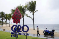 A police officer walks past a G20 sign in Nusa Dua, Bali, Indonesia, Thursday, July 7, 2022. Foreign ministers from the Group of 20 leading rich and developing nations are gathering in Indonesia's resort island of Bali for talks bound to be dominated by the conflict in Ukraine despite an agenda focused on global cooperation and food and energy security. (AP Photo/Dita Alangkara)