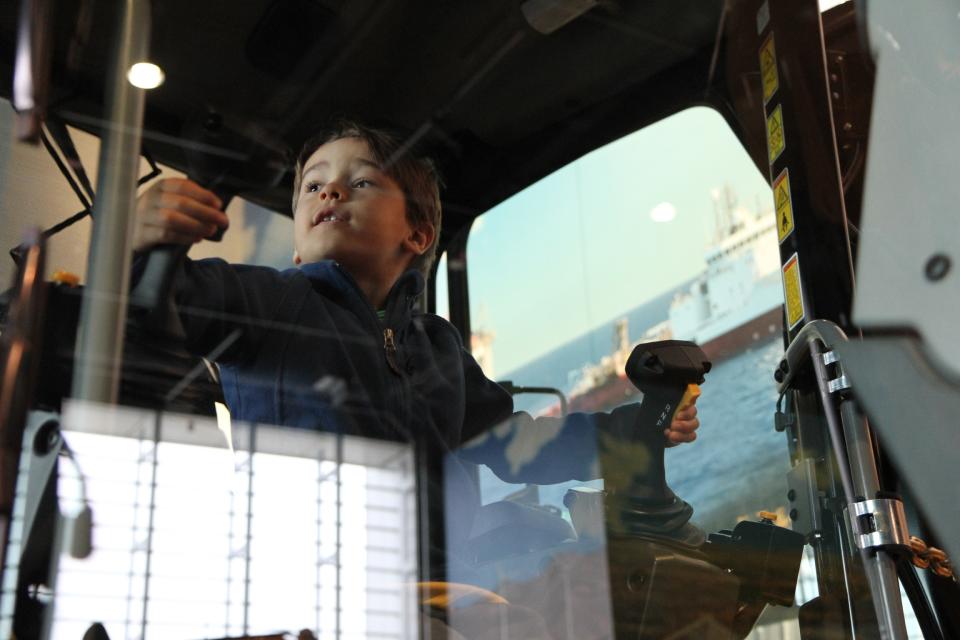 This December 2012 photo shows a boy testing equipment on display at the Caterpillar Visitors Center in Peoria, Ill. Caterpillar Inc. manufactures heavy equipment that bulldozes, digs, lifts and performs other tasks at construction and mining sites. The center lets visitors climb inside the machines for a closer look while computer simulations provide an opportunity to learn how to manipulate the controls. (AP Photo/Fritz Faerber)