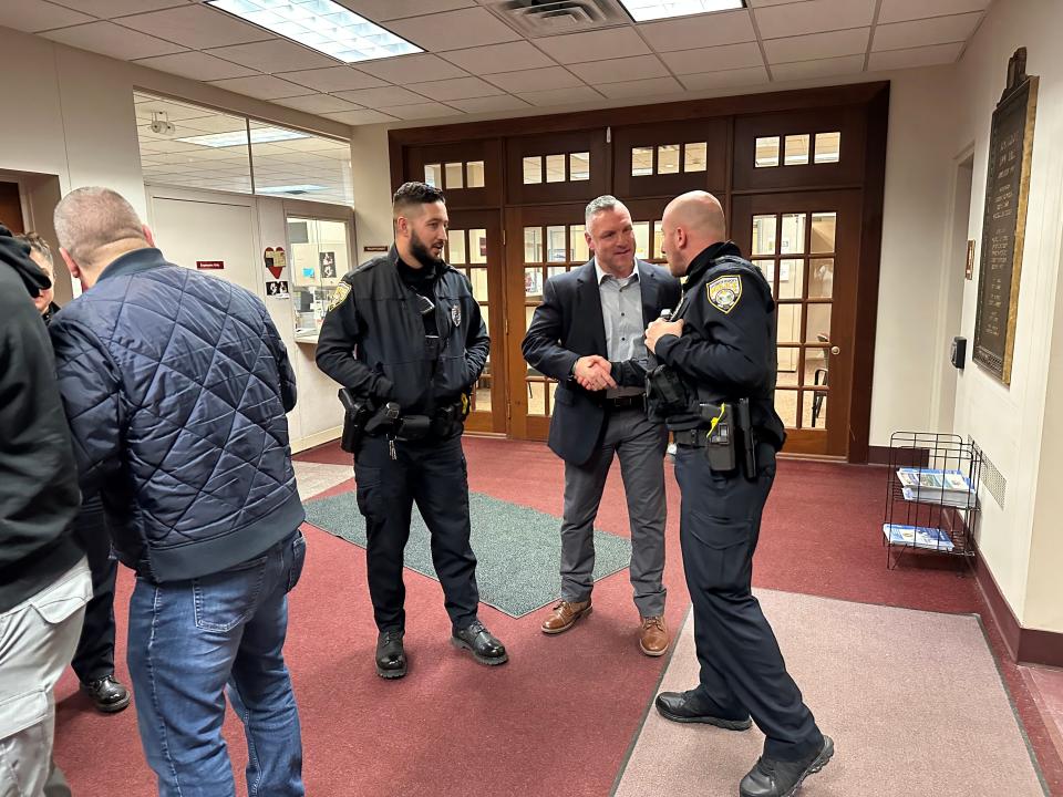 Scott Peters, center, speaks with several Irondequoit police officers after the Jan, 17, 2023 meeting in which he was appointed as the department's next chief.